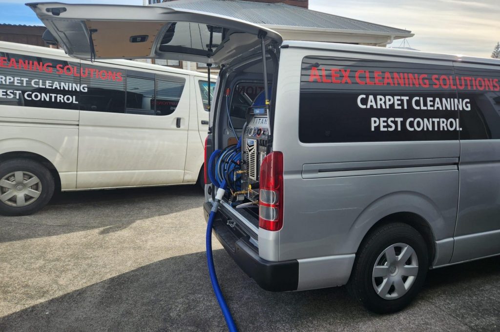Alex Cleaning Solutions Auckland team with vans and truck mount — 20 years experience, no hidden costs.